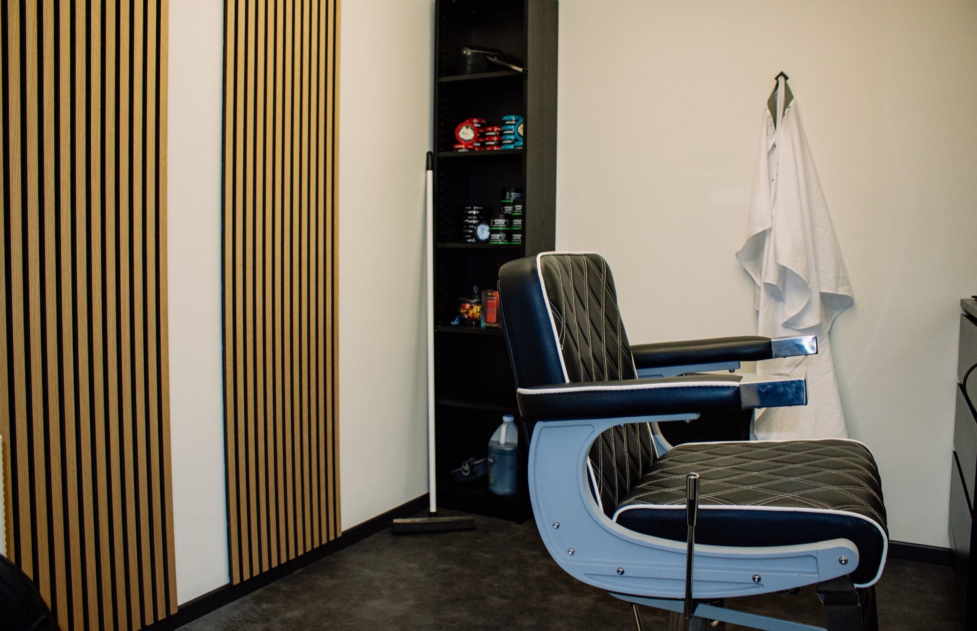 Het interieur van HJ's Barber Lounge: houten latten, schap en warm licht
